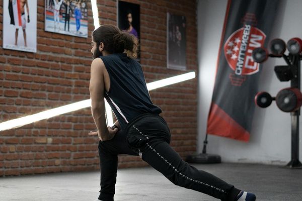 Young man demonstrating flexibility during a dynamic warm up session.